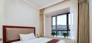 Une chambre dâhĂŽtel avec un lit, une fenĂȘtre avec des rideaux et une vue sur des immeubles.