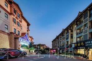 A multi-story hotel with a traditional architectural style, featuring balconies and a central courtyard.