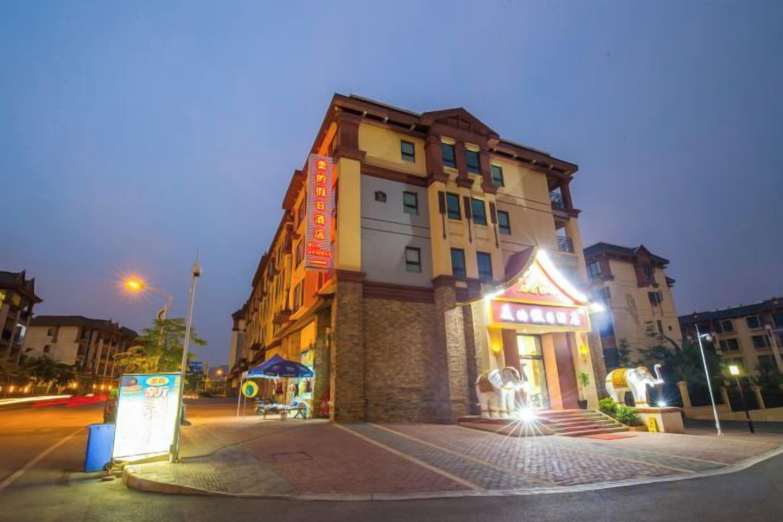 Un hotel con una entrada destacada, un letrero visible y una fachada bien iluminada.