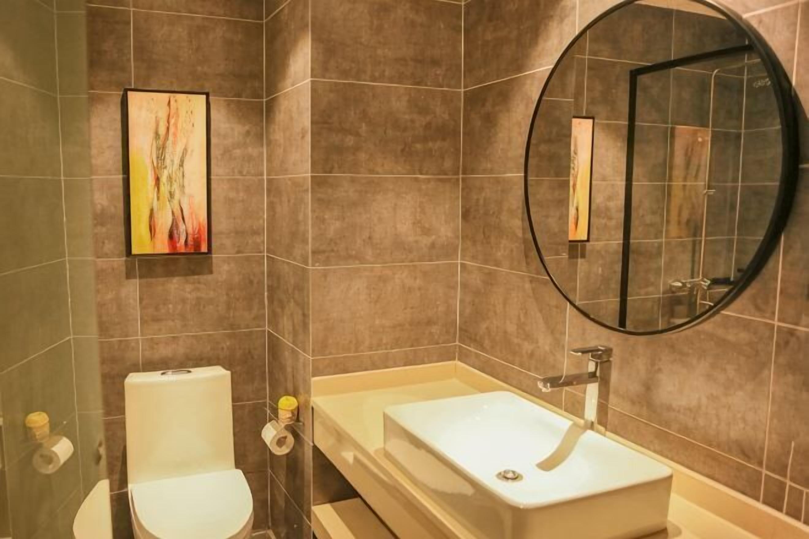 Une salle de bain avec des toilettes, un lavabo et un miroir.