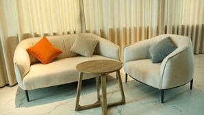 A room with a sofa, a chair, and a small wooden table.