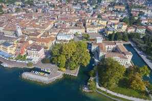 Une vue aérienne d’une ville avec des bâtiments urbains denses, un front de mer et un grand arbre.