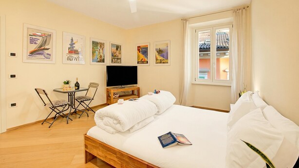 Une chambre d’hôtel comprenant un lit, un bureau avec une chaise, une télévision et des œuvres d’art murales.