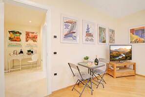 Un salon moderne comprenant un coin repas, un téléviseur et des œuvres d’art murales.