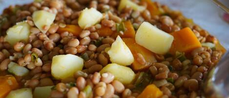 A close-up of a dish with lentils, potatoes, and carrots.