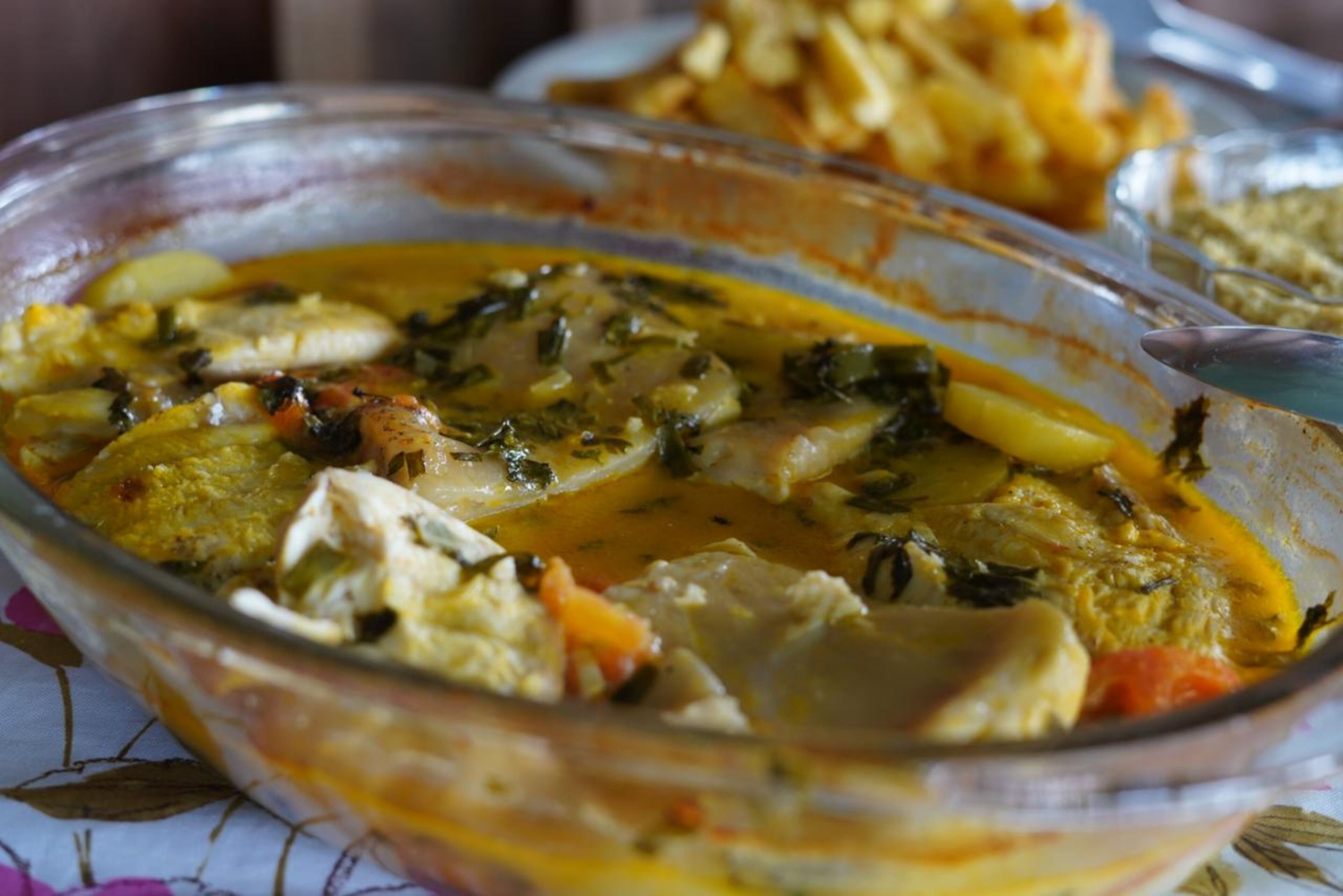 A glass bowl filled with a stew containing vegetables and meat.