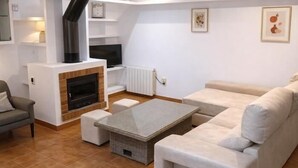 A modern living room with a fireplace, sofa, and television. - Casa Brisa in S'agaro with sea views and private garden (Sant Feliu de Guíxols)