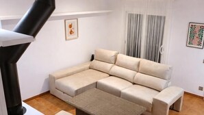 A living room with a sectional sofa, a small coffee table, and a fireplace. - Casa Brisa in S'agaro with sea views and private garden (Sant Feliu de Guíxols)