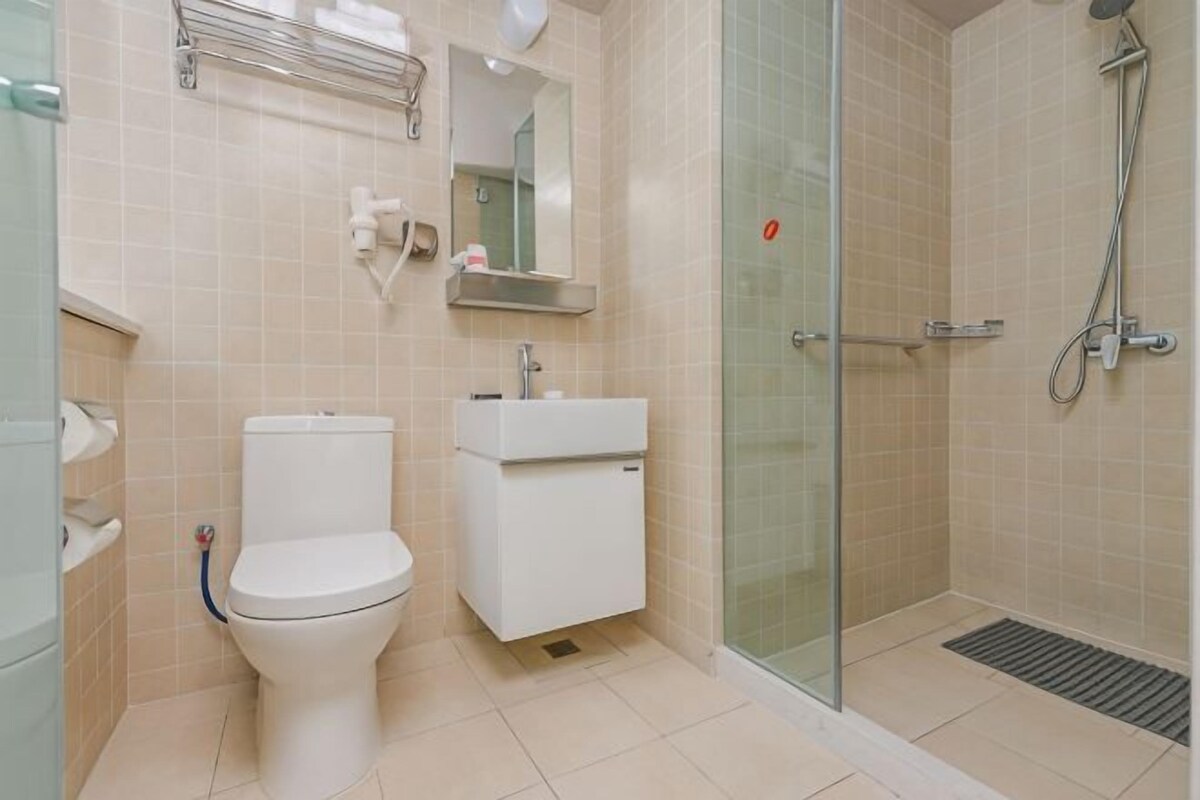 A bathroom with a toilet, sink, and shower.