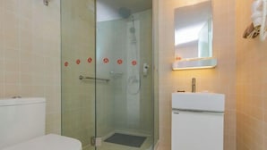 A bathroom with a glass-enclosed shower, a white toilet, and a sink with a mirror above it. - Jinjiang Inn Select (Tianshui)