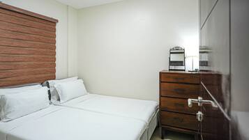 A bedroom with a bed, a wooden headboard, a dresser with drawers, and a mirror.