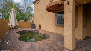 A house with a swimming pool, a covered patio, and a beige exterior. - Beautiful patio home in exclusive Cave Creek (Cave Creek)