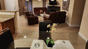 A modern living room with a fireplace, comfortable seating, and a dining area with a glass table. - ★Strip views w/amenities! Pool, fitness center, W/D in-unit & FREE parking!★ (Las Vegas)