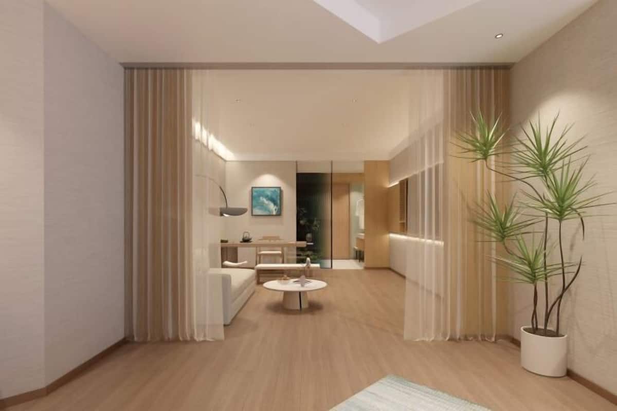 Un interior moderno con una mesa redonda central, un sofá y una planta en maceta.