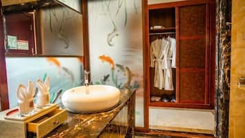 A bathroom with a marble sink, a towel rack, and a wooden cabinet.