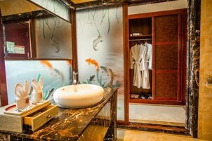 Un baño con un lavabo de mármol, un perchero y un armario de madera.