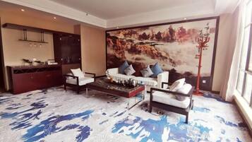 A modern living room with a large painting, a sofa set, a coffee table, and a decorative floor lamp.