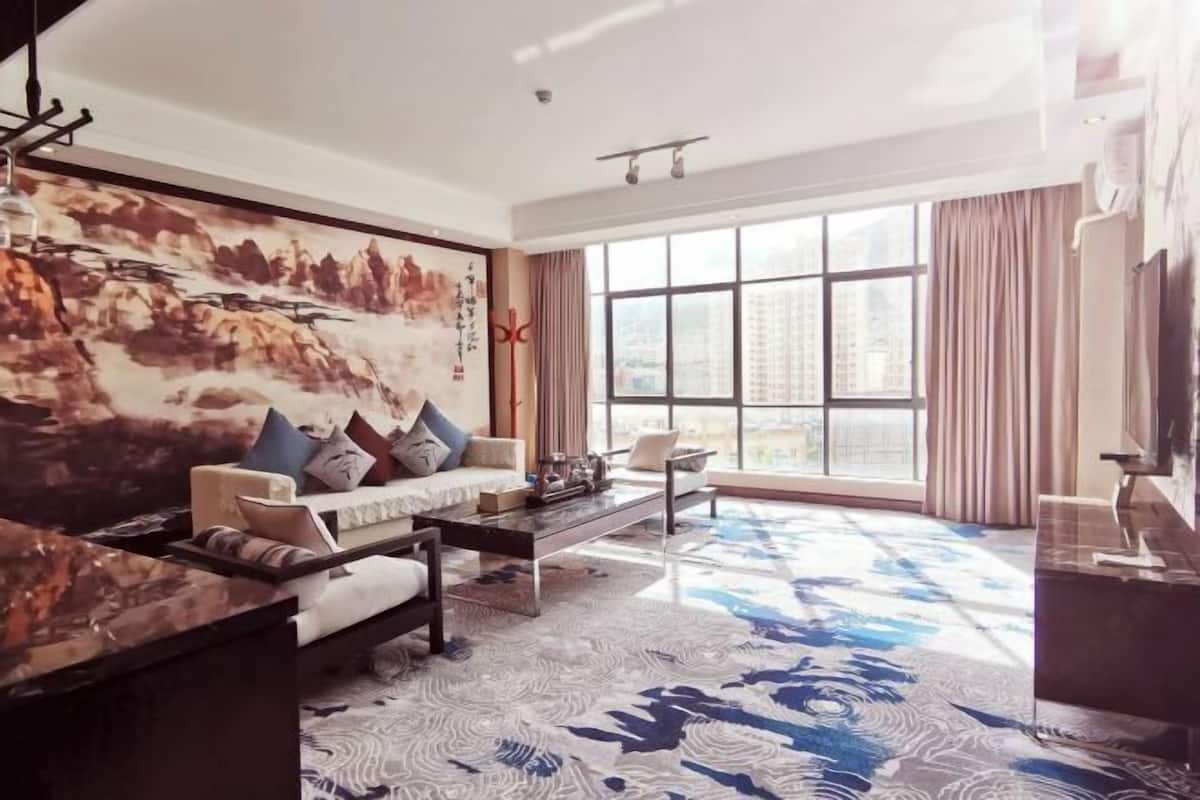 Una sala de estar moderna con sofá, mesa de centro y una obra de arte en la pared.
