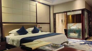 A hotel room with a large bed, a wooden nightstand, and a painting on the wall.