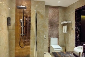 A modern bathroom with a glass-enclosed shower, a toilet, and a sink.