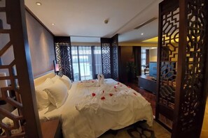 Ein Hotelzimmer mit einem Bett, dekorativen Raumteilern und Blick ins Freie.