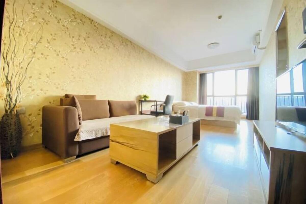 Ein Wohnzimmer mit einer Couch, einem Couchtisch und einem Fernseher.