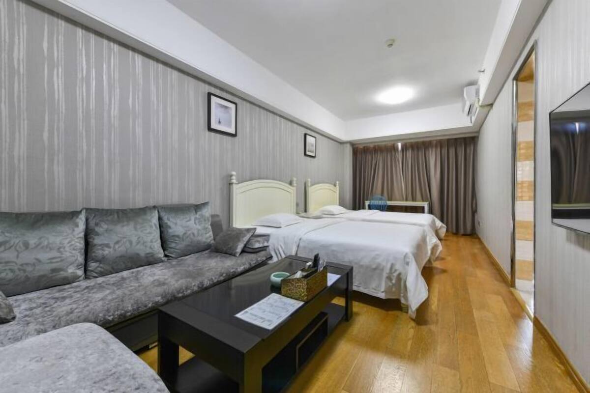 Ein Hotelzimmer mit einer Couch, einem Bett, einem Nachttisch und einem Fernseher.