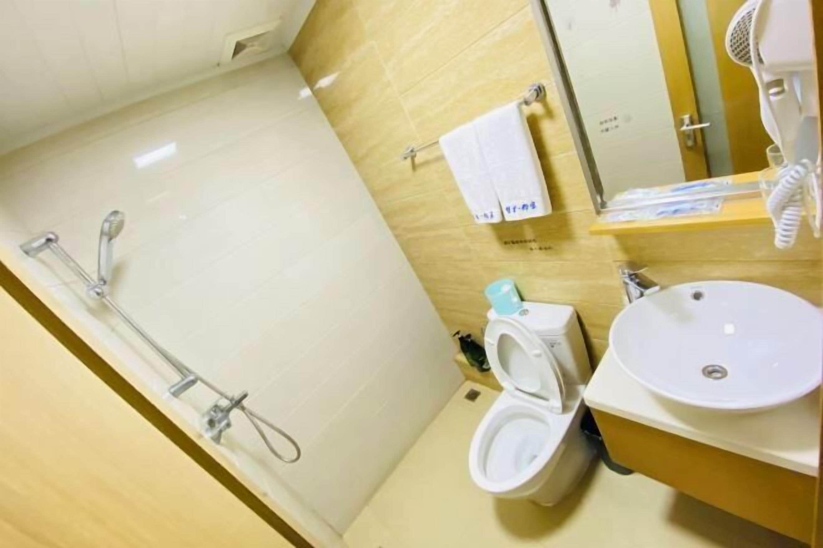 Un baño pequeño con inodoro, lavamanos y ducha.