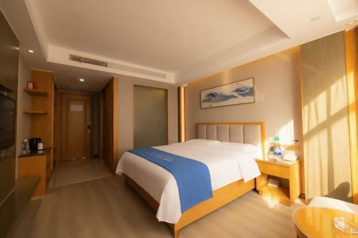 Ein Hotelzimmer mit Bett, Nachttisch und einem Bild an der Wand.