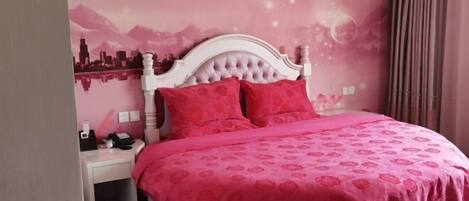 Un dormitorio con un mural de paisaje urbano, un cabecero blanco capitonado y una colcha rosa.