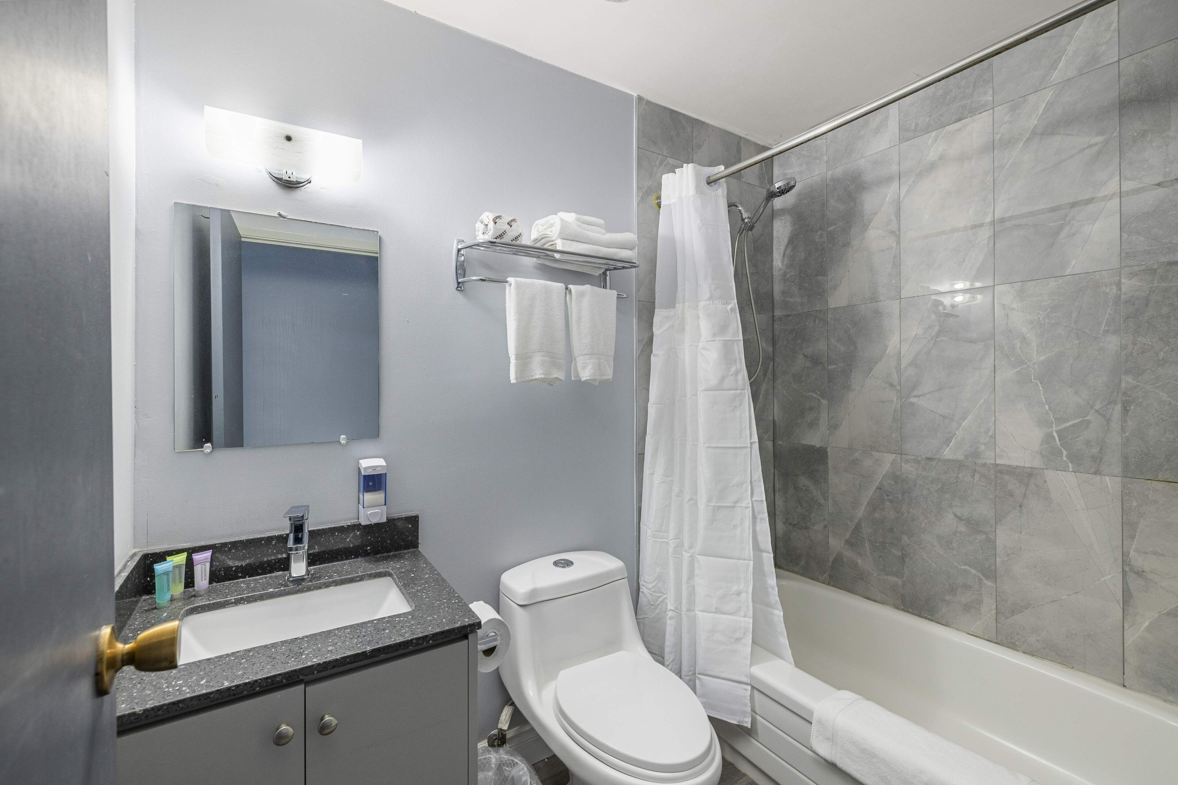 A modern bathroom with a sink, toilet, and shower.
