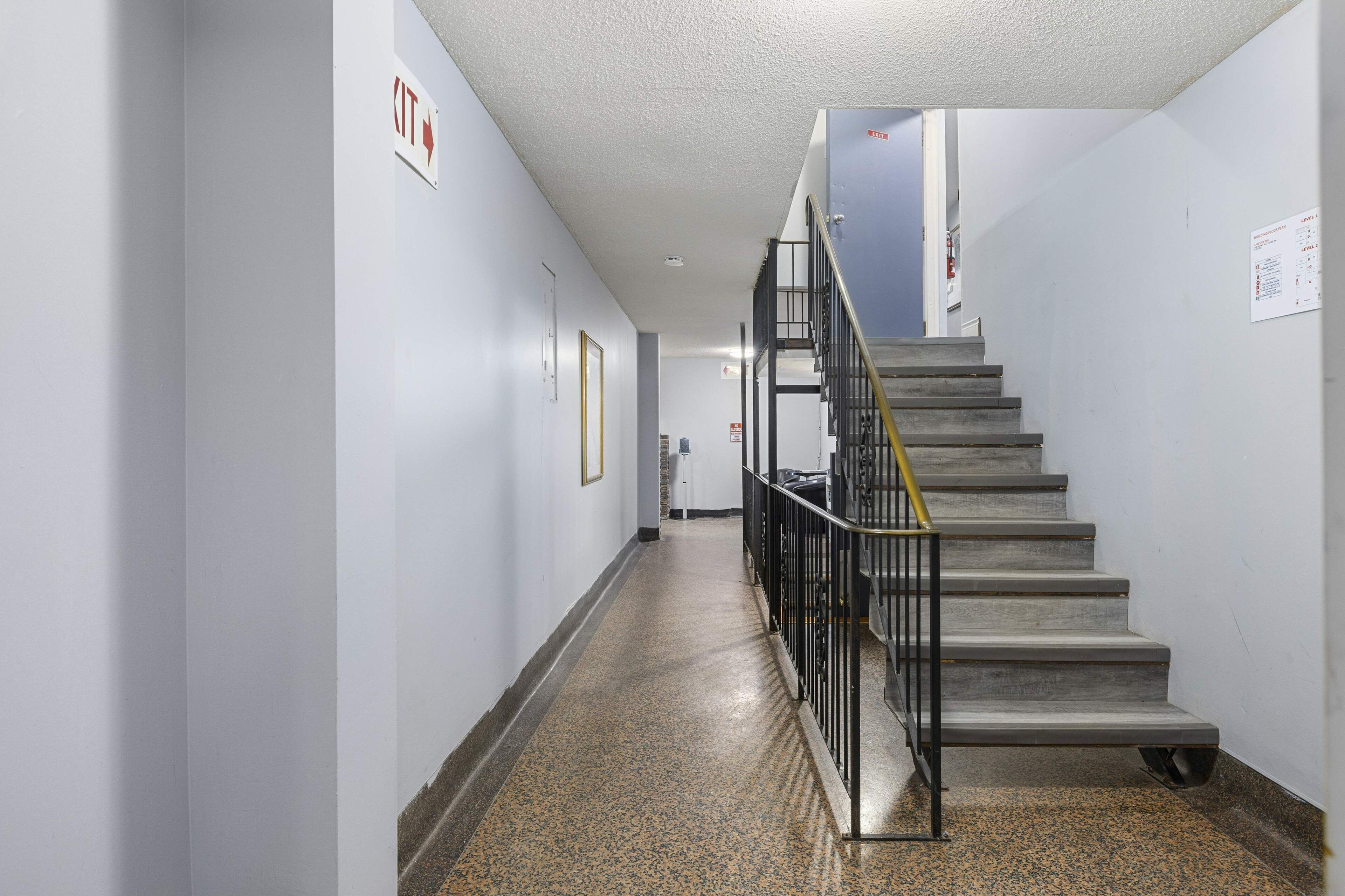Un pasillo con una escalera que sube a un piso superior.