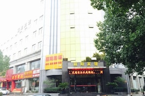 A hotel with a modern facade, a prominent entrance with signage, and a visible parking area. - Liyang Hotel (Huzhou)