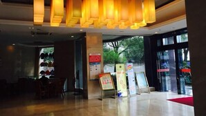 Una hall dal design moderno, con area salotto, reception e cartelli informativi.