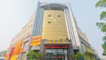 A multi-story hotel with a prominent entrance, signage, and a vertical strip of windows.