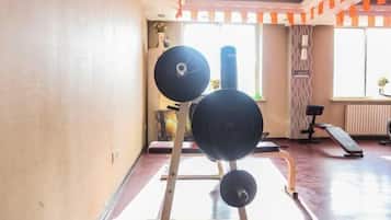 Un gimnasio con una estructura para sentadillas, un saco de boxeo y un banco.