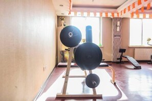 A gym with a squat rack, a punching bag, and a bench.