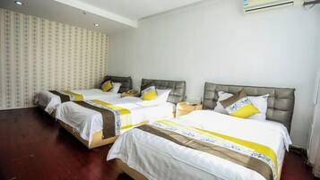 A hotel room with two beds, each with a headboard, bedside tables, and a neutral color scheme.