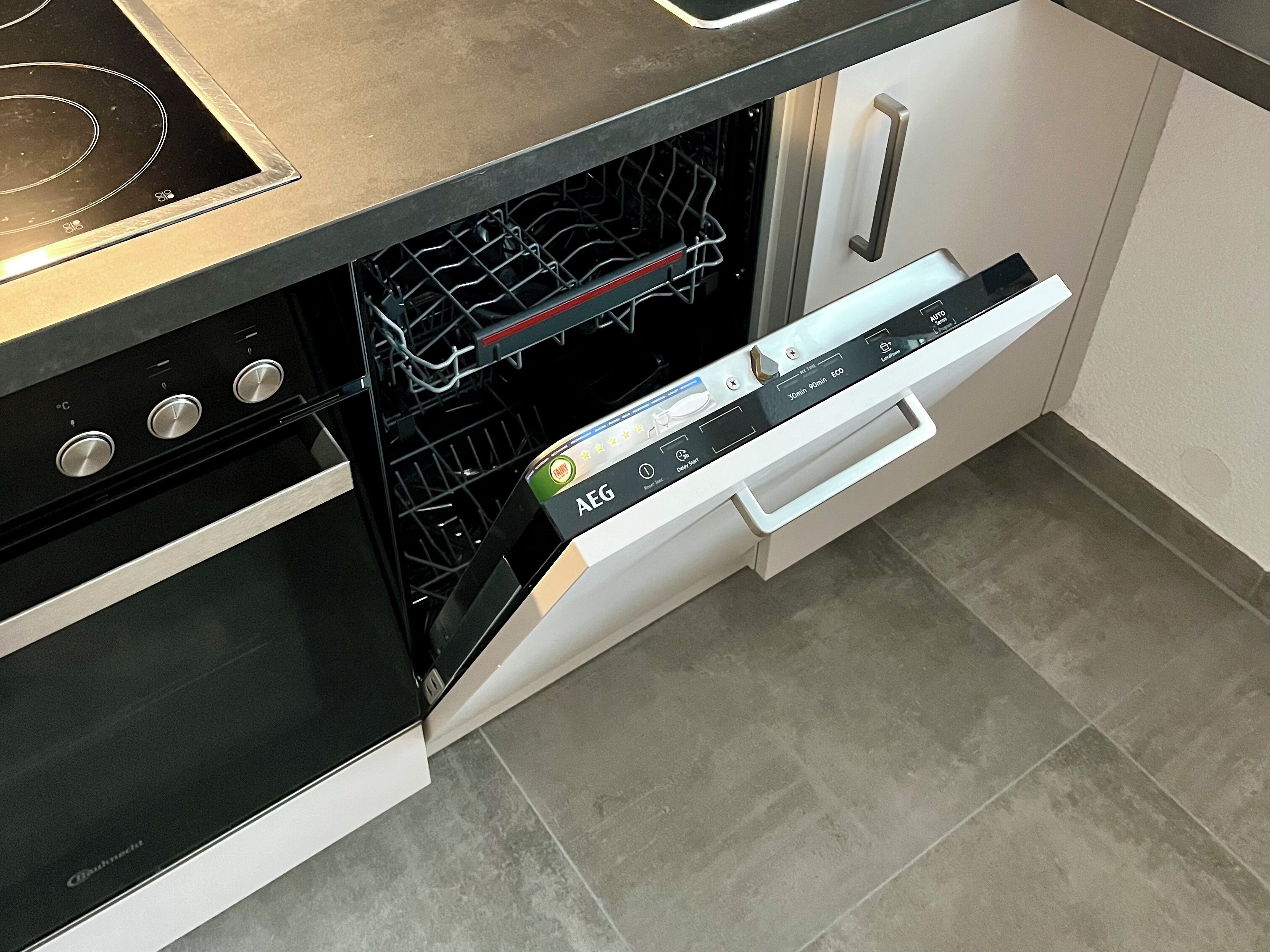 A kitchen with a built-in dishwasher, an oven, and a stainless steel countertop.