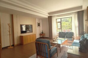 Un soggiorno con un divano, una televisione e un tavolino in vetro.