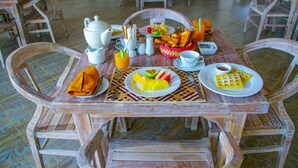 Uma mesa de jantar de madeira com cadeiras, pratos de comida e vários utensílios de mesa.