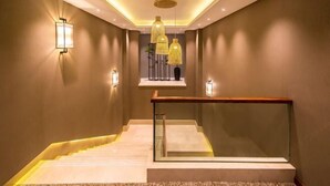 Una escalera moderna con barandas de vidrio e iluminación empotrada.