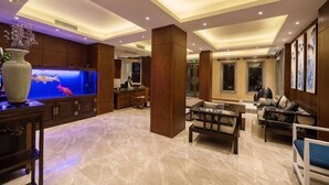 Un vestíbulo amplio con un gran acuario, muebles de madera y una recepción.