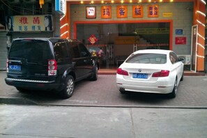 Two cars parked in front of a building with a sign that reads 'Maria's'. - Makeboat Hotel (Zhuhai Lovers Road Riyuebei Branch) (Zhuhai)