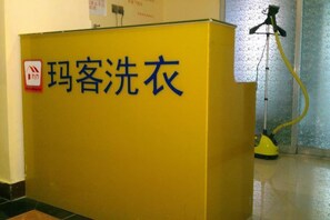 A yellow cabinet with Chinese characters, a vacuum cleaner, and a no-smoking sign. - Makeboat Hotel (Zhuhai Lovers Road Riyuebei Branch) (Zhuhai)