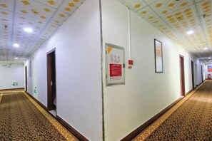 A corridor with doors, a carpeted floor, and a ceiling with recessed lighting. - Makeboat Hotel (Zhuhai Lovers Road Riyuebei Branch) (Zhuhai)
