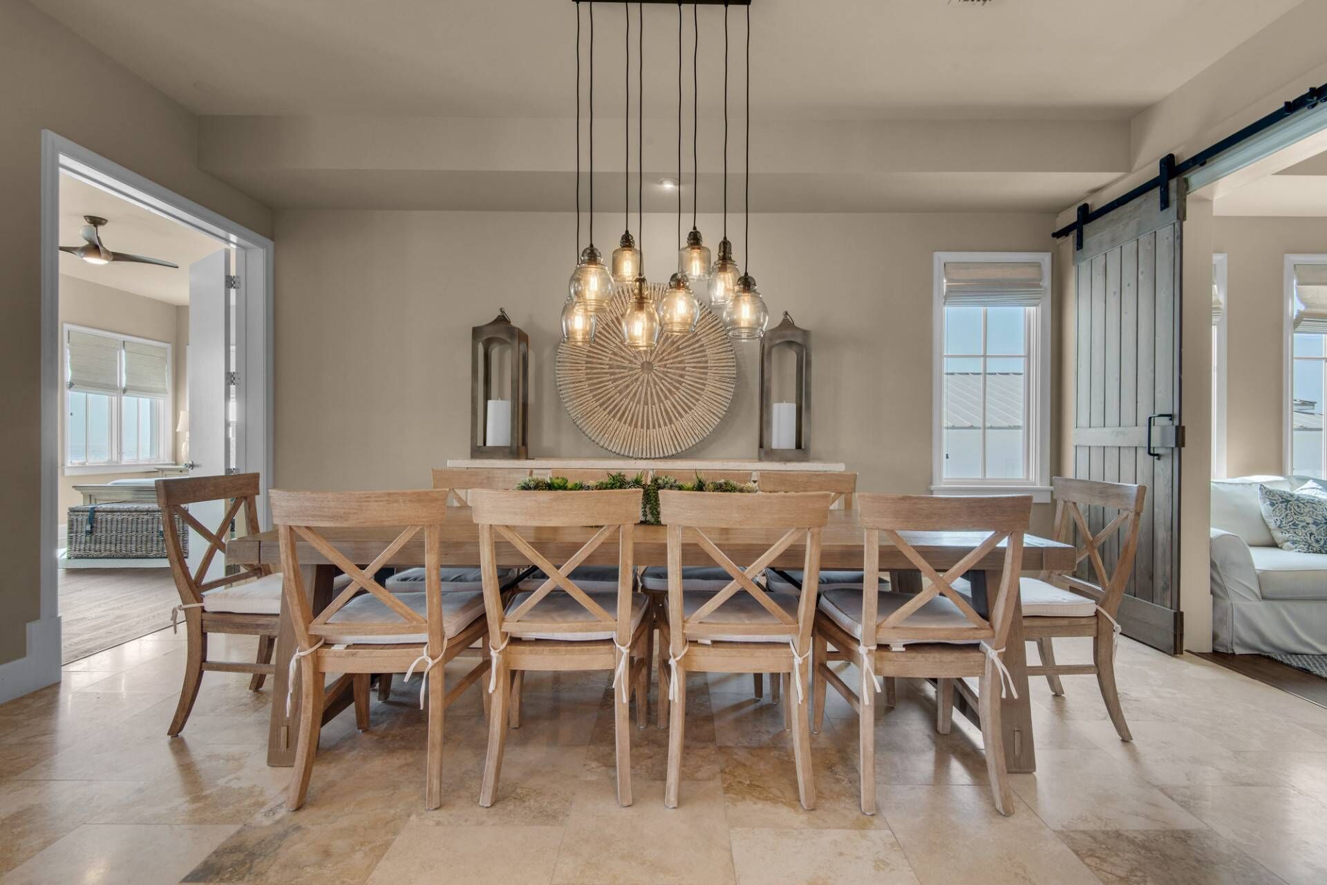 A dining area with a wooden table and chairs, a chandelier, and decorative wall pieces.
