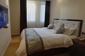 A hotel room with a large bed, a television on the wall, and a window with curtains. - Impression Nanlin Hotel (Nanping)