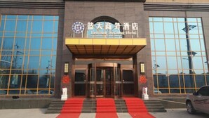 The entrance to the Eastern Business Hotel with a red carpet and glass doors. - Lan Tian Business Hotel (Wuyang)