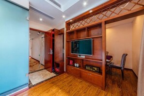 A room with a wooden entertainment unit, a television, and a seating area. - Bojuejioudian (Daozhen)